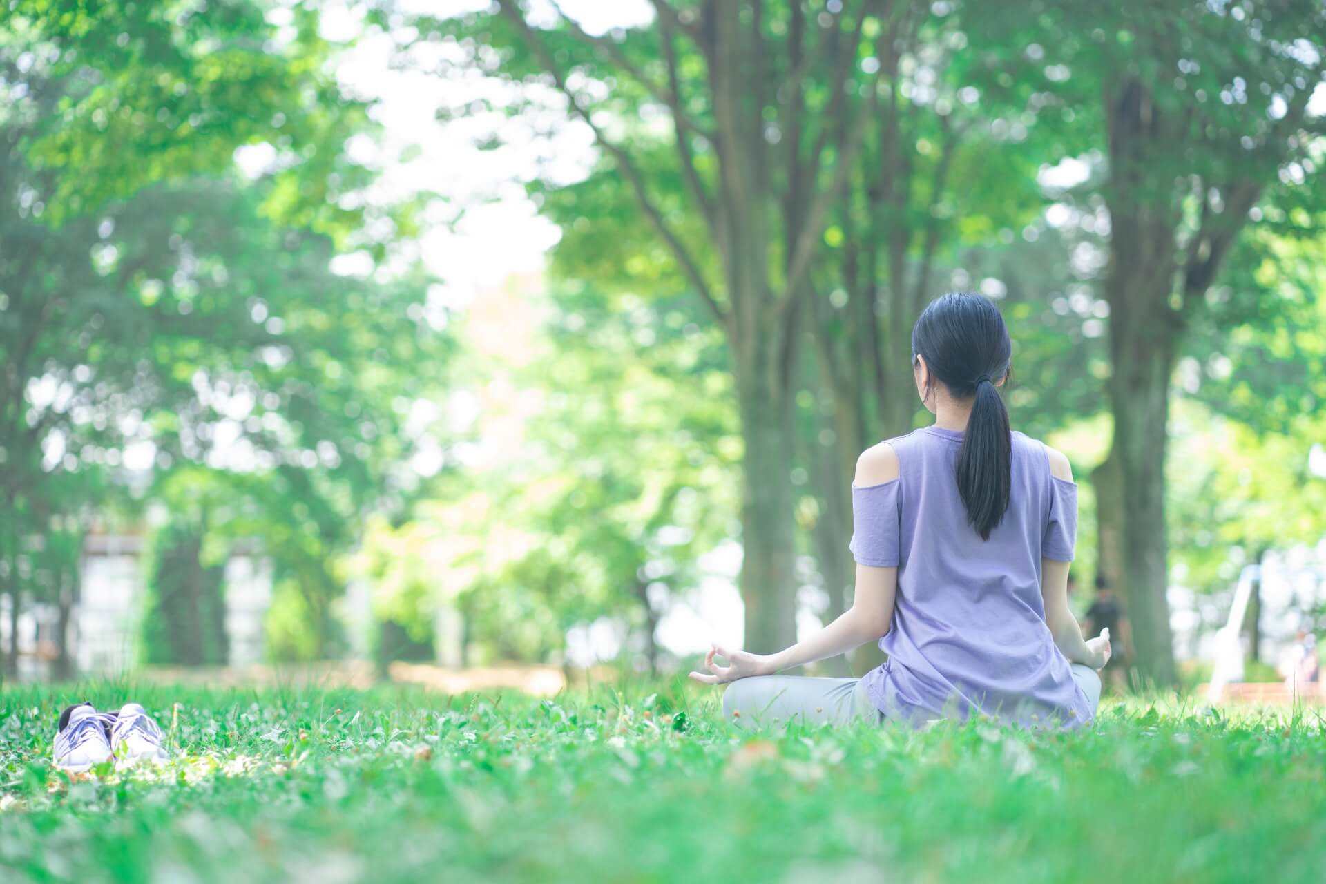 女性が自然の中でマインドフルネスをしている