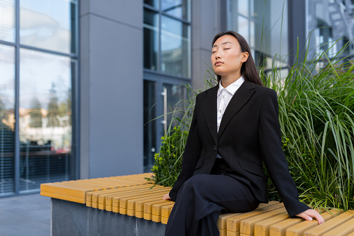 ベンチで深呼吸している女性